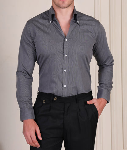 Man wearing a gray italian vega shirt and black gurkha pants against a neutral background
